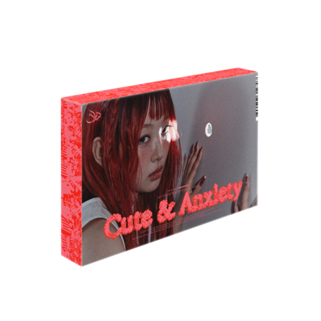 A boxed product package shown at an angle on a plain white background. The box features a red side panel with repeating text and a front cover showing a woman with red hair against a gray background, with the title 'Cute & Anxiety' in red script.